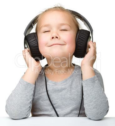 Cute girl enjoying music using headphones