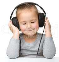 Cute girl enjoying music using headphones