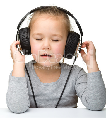 Cute girl enjoying music using headphones