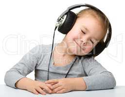 Cute girl enjoying music using headphones