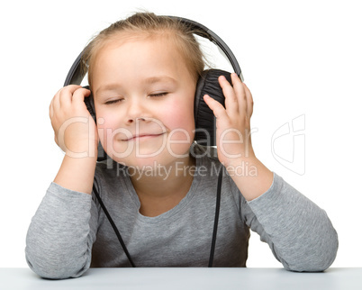 Cute girl enjoying music using headphones