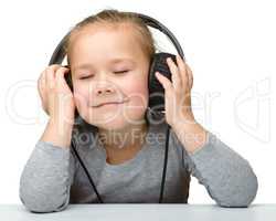 Cute girl enjoying music using headphones