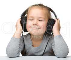 Cute girl enjoying music using headphones