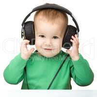 Cute boy enjoying music using headphones