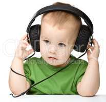 Cute little boy enjoying music using headphones