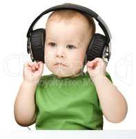 Cute little boy enjoying music using headphones