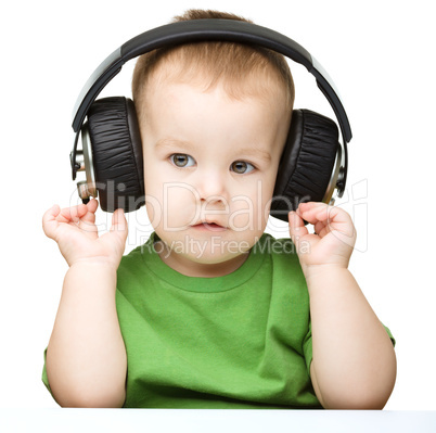 Cute little boy enjoying music using headphones