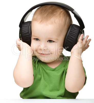 Cute boy enjoying music using headphones