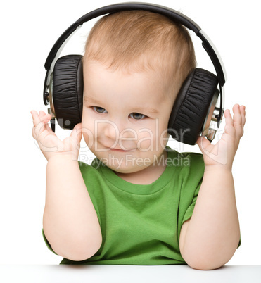 Cute little boy enjoying music using headphones