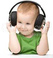 Cute little boy enjoying music using headphones