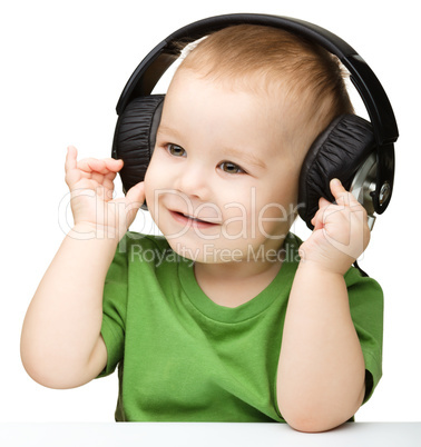 Cute little boy enjoying music using headphones