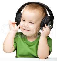 Cute little boy enjoying music using headphones