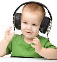 Cute boy enjoying music using headphones