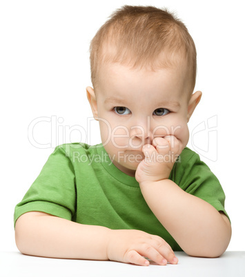 Pensive little boy support his head with hands