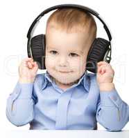 Cute little boy enjoying music using headphones