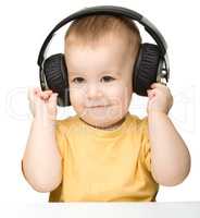 Cute little boy enjoying music using headphones
