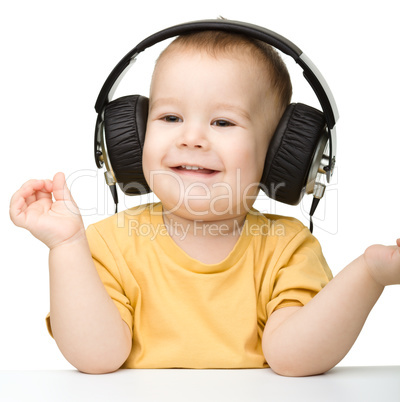 Cute little boy enjoying music using headphones