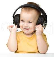 Cute little boy enjoying music using headphones