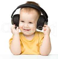 Cute little boy enjoying music using headphones