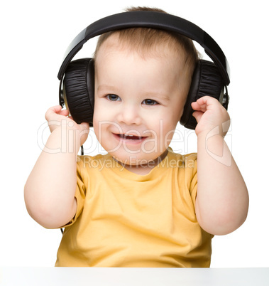 Cute little boy enjoying music using headphones