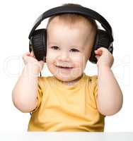 Cute little boy enjoying music using headphones