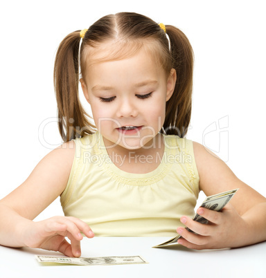 Little girl is counting dollars