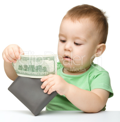 Little boy is playing with dollars