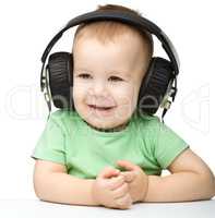 Cute little boy enjoying music using headphones