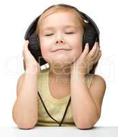 Cute girl enjoying music using headphones