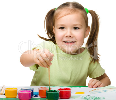 Cute cheerful child play with paints