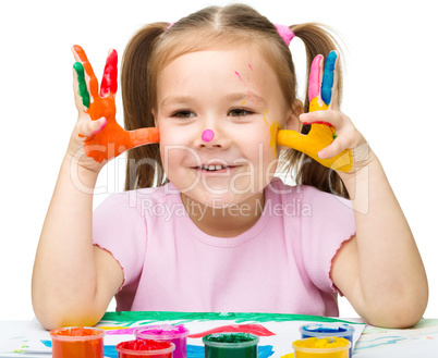 Portrait of a cute girl playing with paints