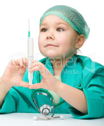 Cute little girl is playing doctor with syringe