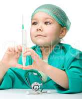 Cute little girl is playing doctor with syringe
