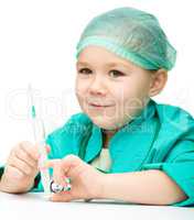 Cute little girl is playing doctor with syringe