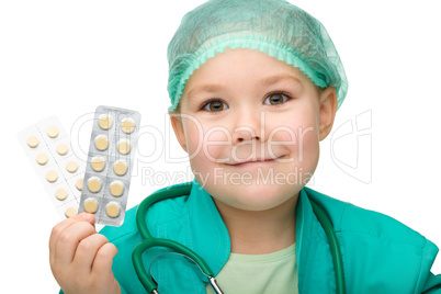 Cute little girl is playing doctor with pills
