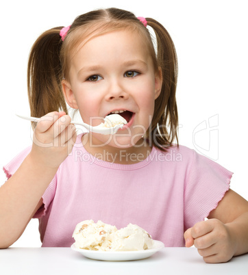 Cute little girl is eating cottage cheese