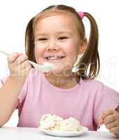 Cute little girl is eating cottage cheese