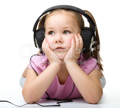 Cute little girl enjoying music using headphones