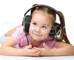 Cute little girl enjoying music using headphones