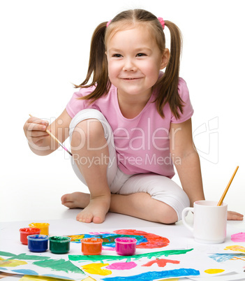 Cute cheerful child play with paints