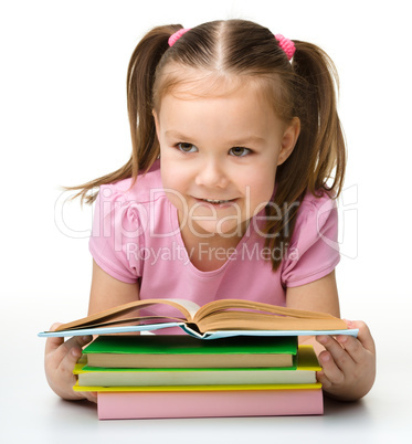 Cute little girl reads a book