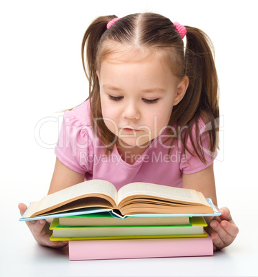 Cute little girl reads a book