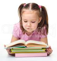 Cute little girl reads a book