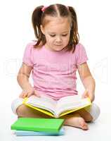 Cute little girl reads a book