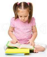 Cute little girl reads a book