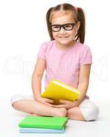 Cute little girl reads a book