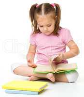 Cute little girl reads a book