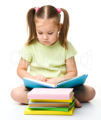 Cute little girl reads a book