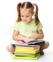 Cute little girl reads a book