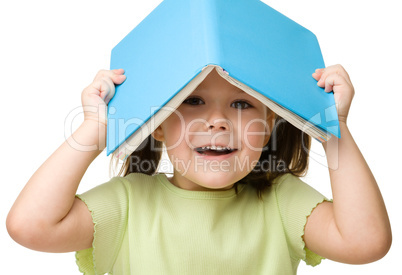 Cute little girl plays with book